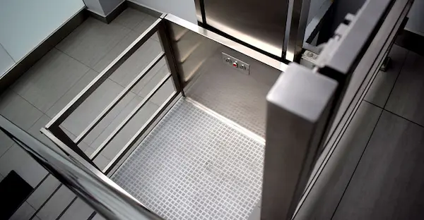 señor usando un elevador de discpacitados para subir las escaleras